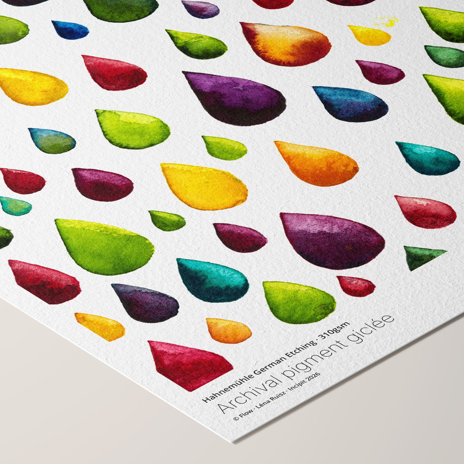 Corner of the Flow fine art print on Hahnemühle German Etching paper, scattered rainbow watercolour raindrops on white, shown at an angle revealing paper texture and printed paper credentials.