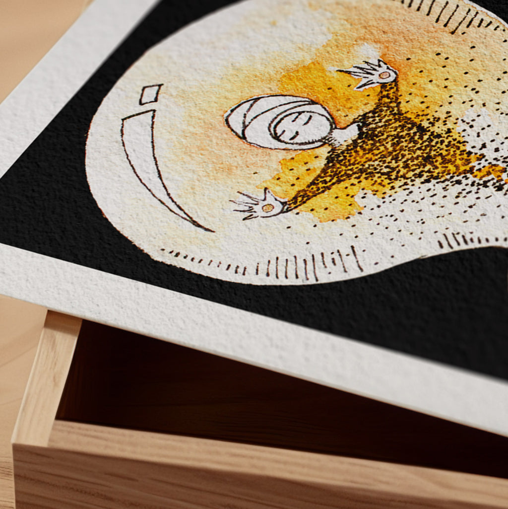 Detail of the Held fine art print resting on a wood surface, showing the deckle paper edge and close-up of the sleeping figure cradled in a glowing golden light in ink and watercolour