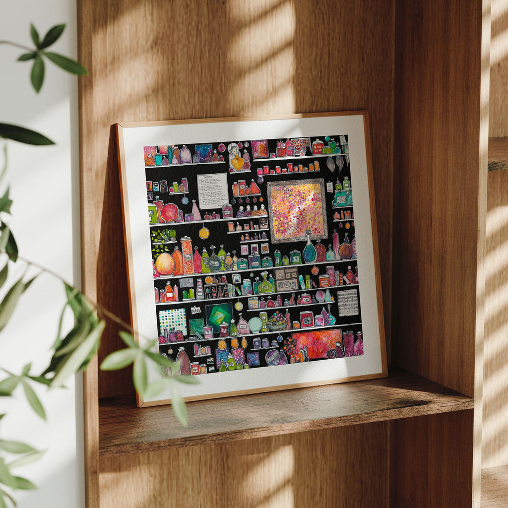 Framed Invictus fine art print leaning on a wooden shelf in dappled daylight, black shelves crowded with jewel-toned potion jars and bottles around a framed dot-motif panel, from Léna Ruisz's Cabinet of Small Worlds collection.