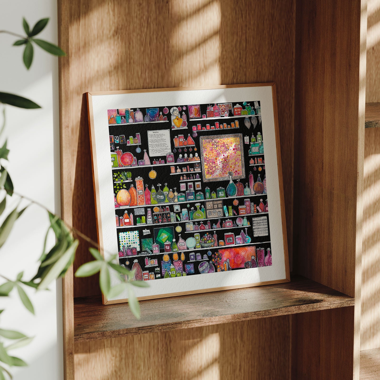 Framed Invictus fine art print leaning on a wooden shelf in dappled daylight, black shelves crowded with jewel-toned potion jars and bottles around a framed dot-motif panel, from Léna Ruisz's Cabinet of Small Worlds collection.