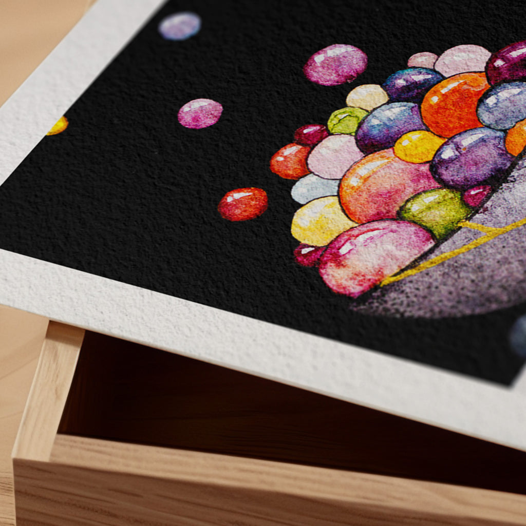 Detail of the Kintsugi fine art print resting on a wood surface, showing the deckle paper edge and close-up of luminous jewel-toned spheres spilling across a black ground in watercolour and ink