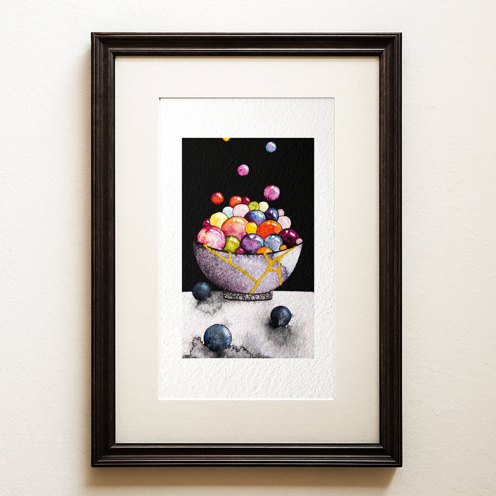 Watercolour and ink on black: a grey bowl mended with gold seams, overflowing with colourful glossy spheres, grey spheres beside it. Kintsugi, a healing fine art print.