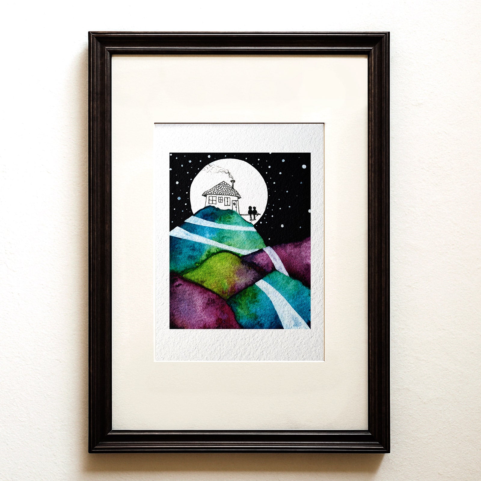 Watercolour and ink on black: two figures on a terrace by a lit house under a full moon, quilted hills and pale roads forking down below. Our Life Pictured fine art print.