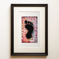 Watercolour: a small black footprint held in a dense field of colourful painted dots in pinks, oranges and blues. Spoor, a colourful new baby fine art print.
